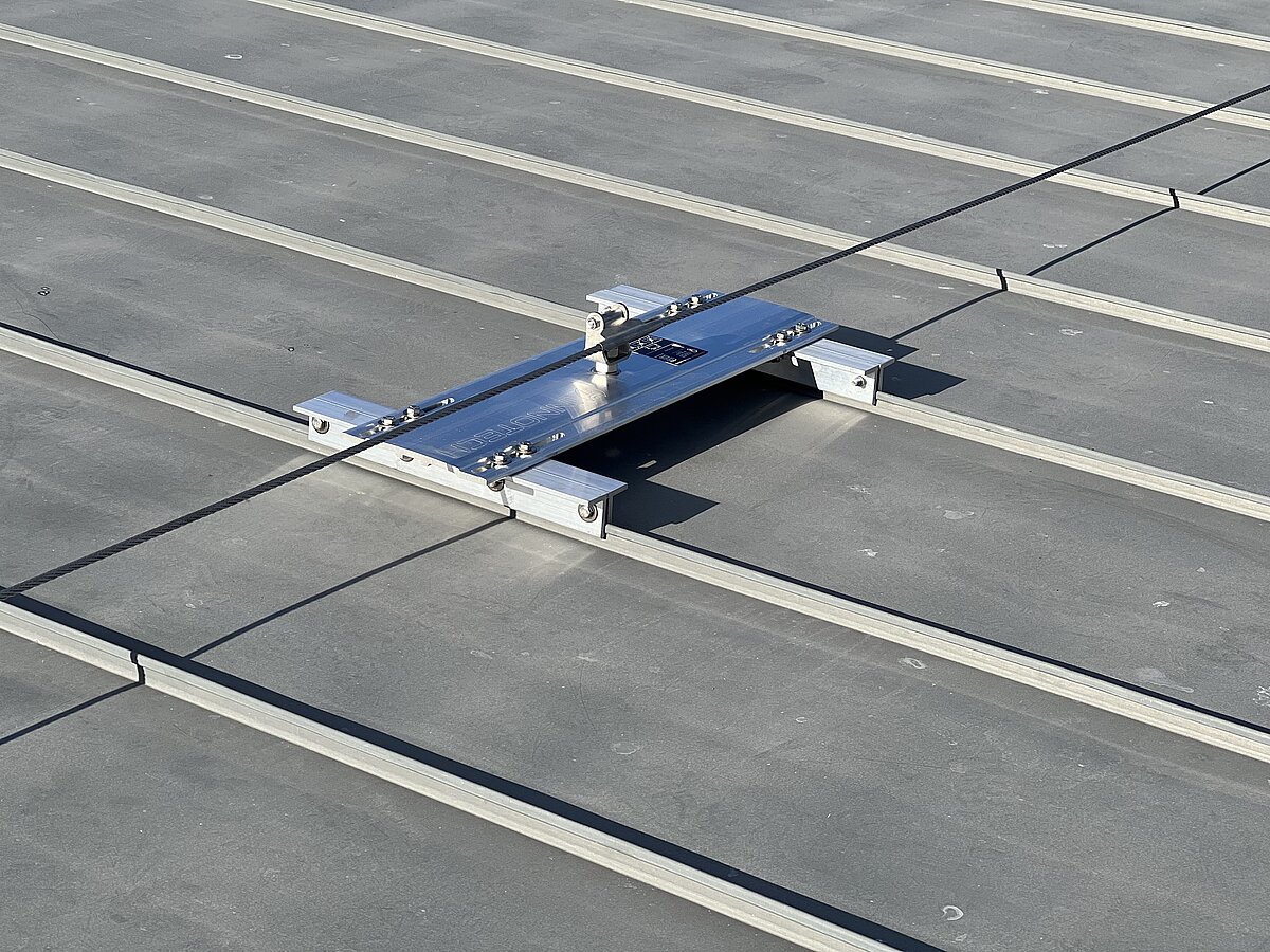 Détail d'un système de retenue par câble sur un toit en tôle pliée